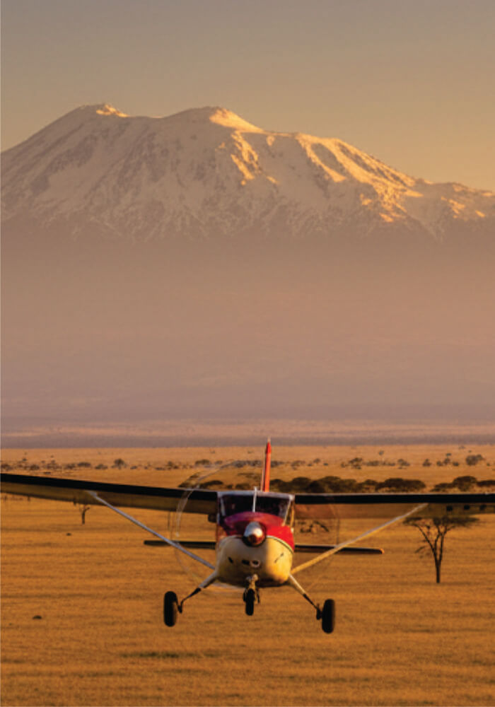 Small airplane on a dirt airstrip with a mountain in the background