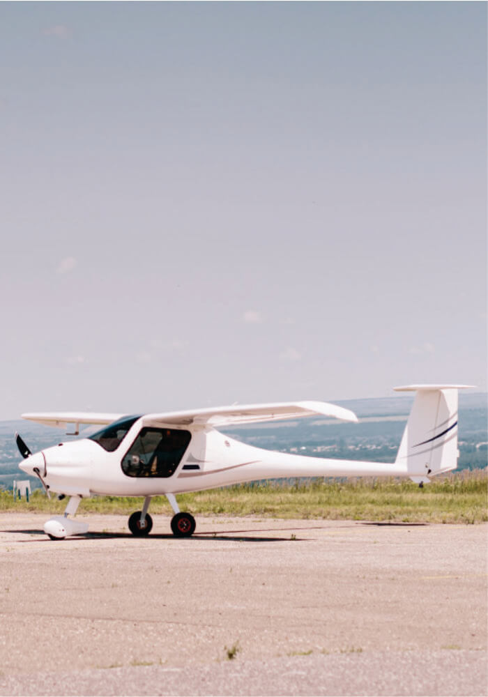 Small white airplane on a runway with a clear sky background