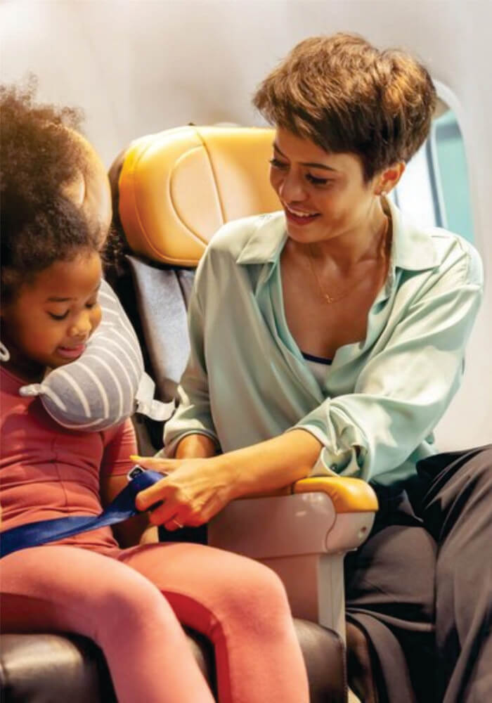 Child's safety belt is being fastened by mom on airplane on Budget Luxury Masai Mara Fly-in safari With Kids