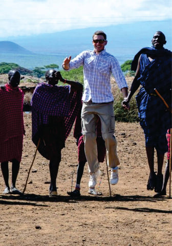 Group of people jumping holding sticks on private luxury Masai village visit