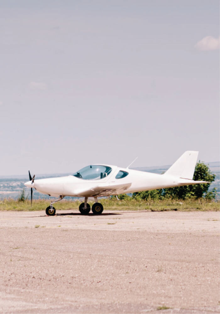 Small white airplane on a runway with a clear sky background